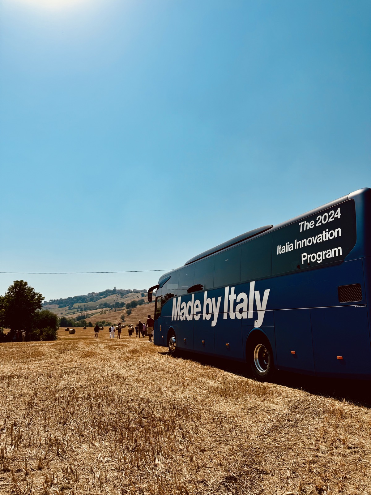 Un autobus del programma fermo in un campo di grano mietuto.